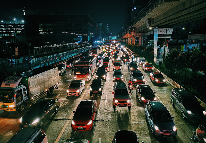 Cars, busses and trains race through a busy futuristic scene.